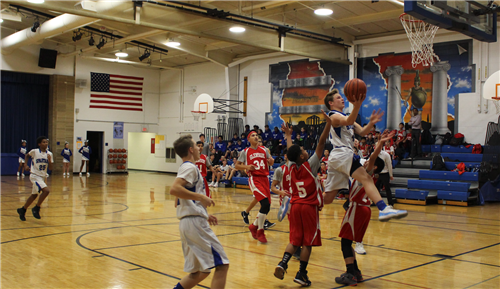 Boys driving to the basket in basketball game 